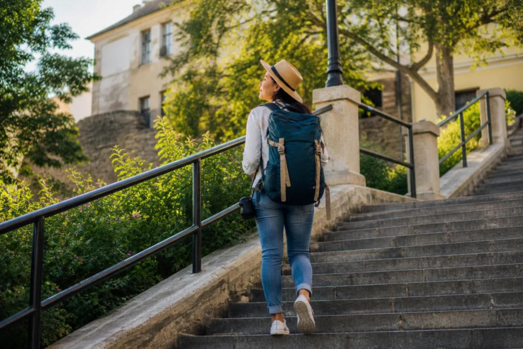 solo traveler walking up city stairs with backpack during short solo trip